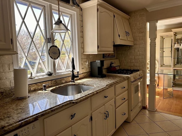 kitchen featuring a sink, white cabinetry, white appliances, crown molding, and light tile patterned floors
