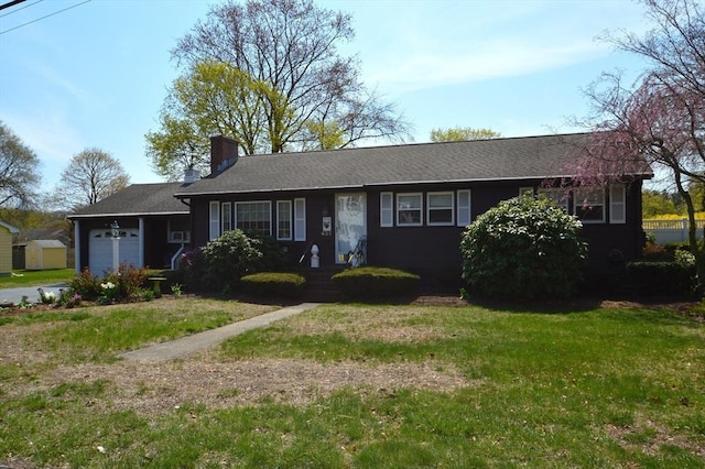 ranch-style home featuring a chimney, a front yard, a storage shed, and a garage