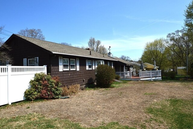 back of house with fence and a wooden deck