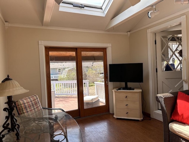 sitting room featuring lofted ceiling with skylight, wood finished floors, and crown molding