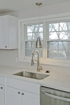 kitchen featuring dishwasher, white cabinets, sink, and plenty of natural light