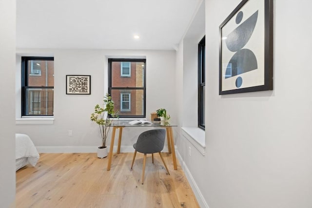 home office with light hardwood / wood-style flooring