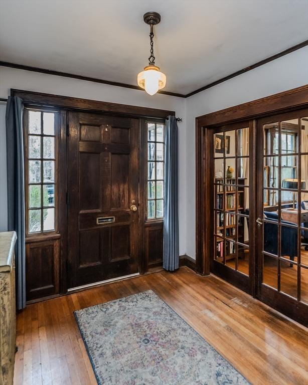 foyer entrance with crown molding, hardwood / wood-style floors, and baseboards