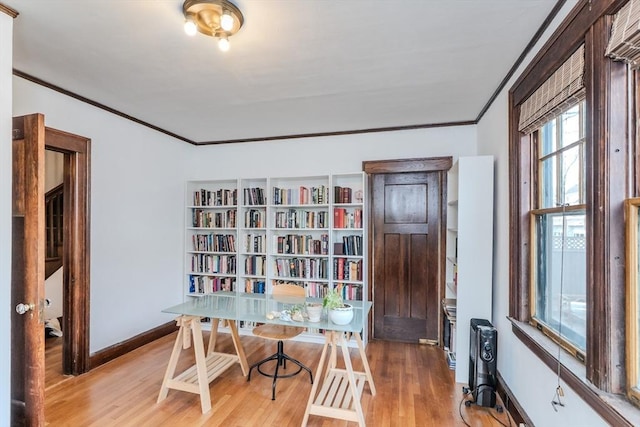 office space featuring baseboards, wood finished floors, and crown molding