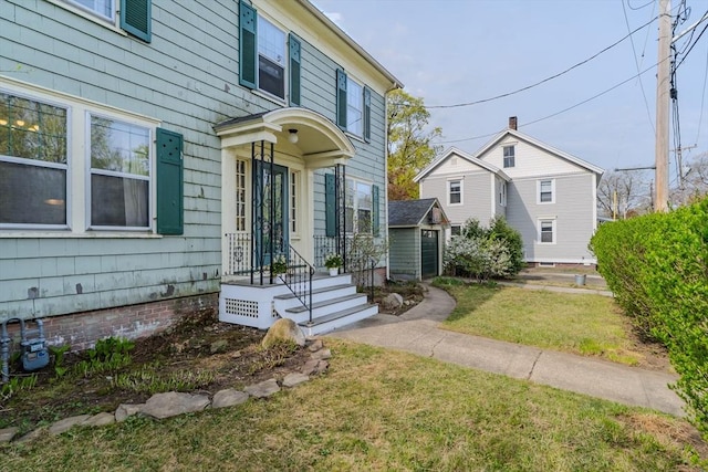 view of front of home featuring a front lawn and an outbuilding