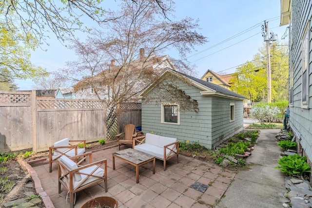 view of patio / terrace featuring fence and an outbuilding