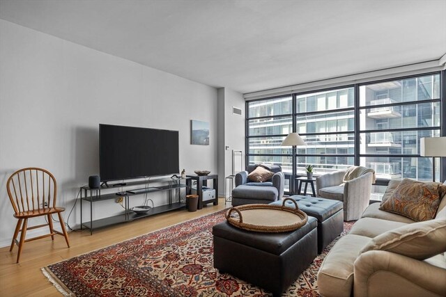 580 Washington St Unit 411, Boston, MA 02111 - living area with expansive windows, baseboards, and wood finished floors