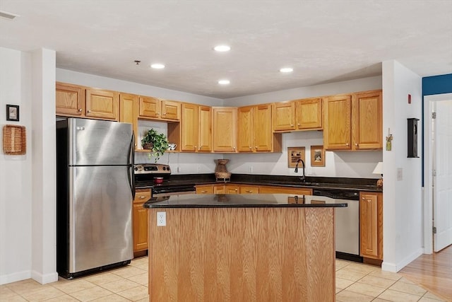 kitchen featuring a center island, dark countertops, recessed lighting, appliances with stainless steel finishes, and a sink