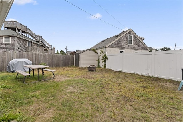 view of yard featuring a storage shed, an outdoor structure, and a fenced backyard