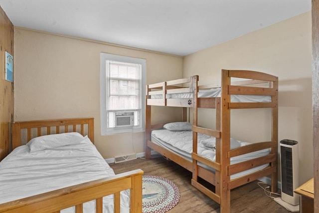 bedroom featuring cooling unit, wood finished floors, visible vents, and baseboards