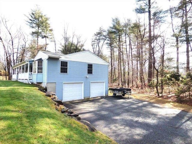 view of side of home featuring a garage, a yard, and a sunroom