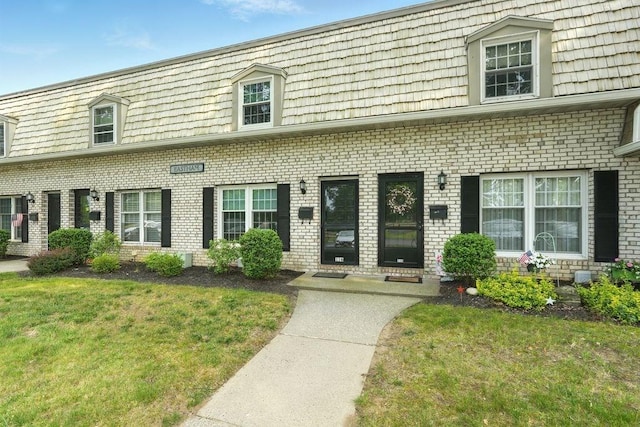 116 Corey Colonial Unit 116, Agawam, MA 01001 - view of front of property with mansard roof, brick siding, and a front lawn
