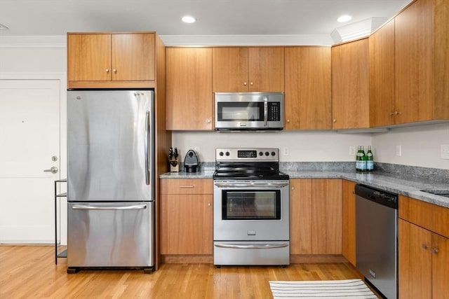 kitchen featuring appliances with stainless steel finishes, light wood-style floors, recessed lighting, and brown cabinets