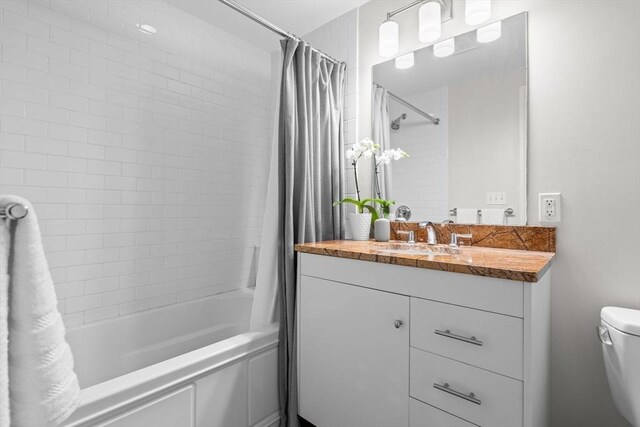 bathroom with shower / bath combination with curtain, toilet, and vanity