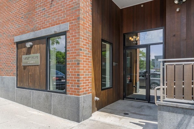 doorway to property featuring brick siding