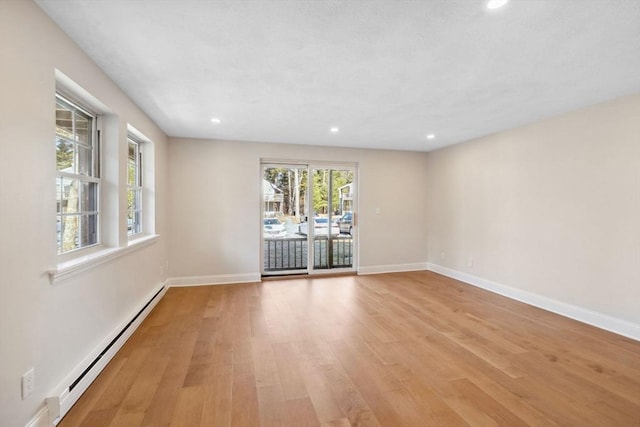 spare room with baseboards, recessed lighting, a baseboard radiator, and light wood-style floors