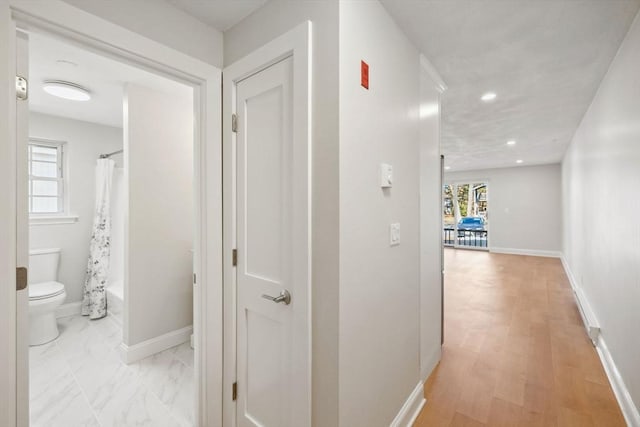 corridor featuring recessed lighting and baseboards