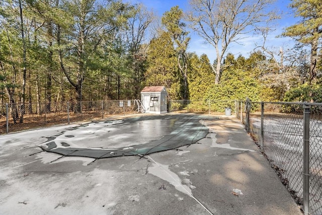 view of pool with a patio area, a fenced backyard, an outdoor structure, and a storage shed