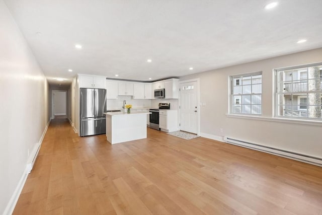 kitchen with white cabinetry, light wood-style flooring, appliances with stainless steel finishes, and a center island