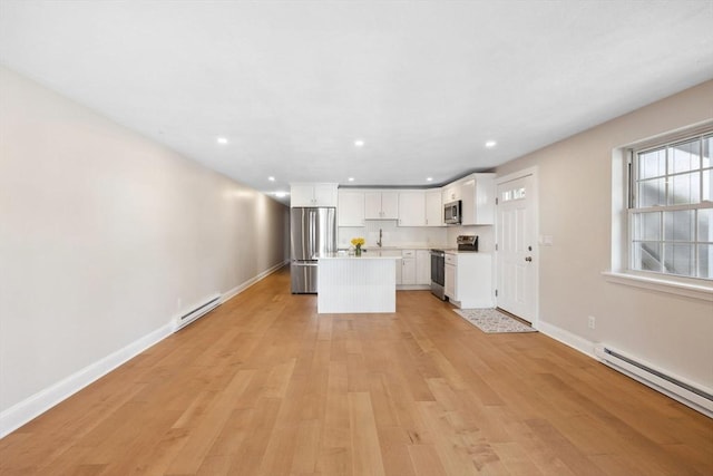 kitchen with a baseboard heating unit, stainless steel appliances, light countertops, and a center island