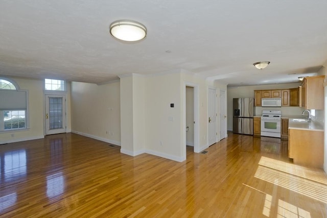 61 Providence Rd Unit 4, Grafton, MA 01519 - unfurnished living room featuring a sink, light wood-style floors, and baseboards