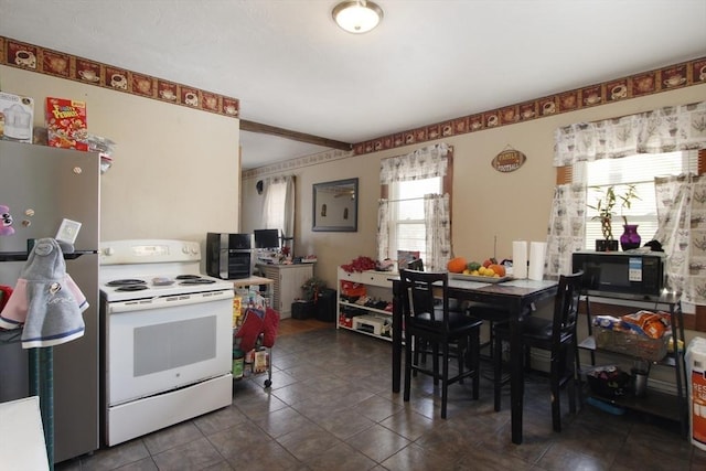 kitchen featuring stainless steel refrigerator, dark tile patterned flooring, and white electric stove