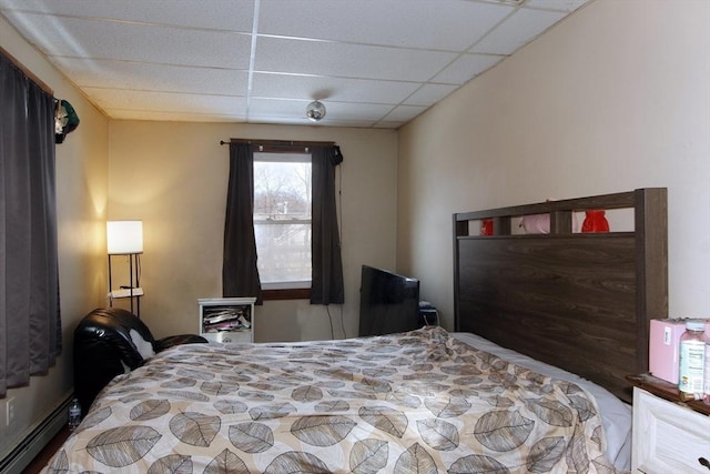 bedroom featuring baseboard heating and a paneled ceiling