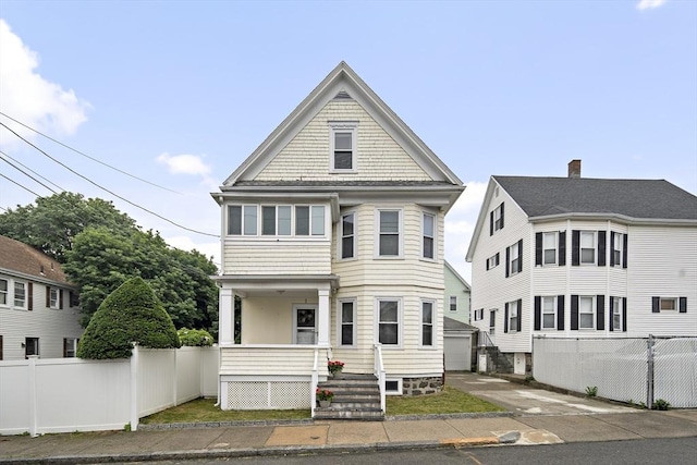 1 Elwood St, Everett, MA 02149 - view of front facade featuring covered porch and a garage