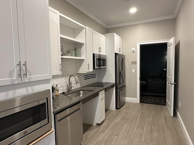 kitchen with white cabinetry, appliances with stainless steel finishes, sink, and dark stone counters