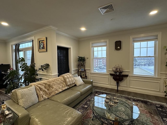 living room with hardwood / wood-style flooring, crown molding, and plenty of natural light