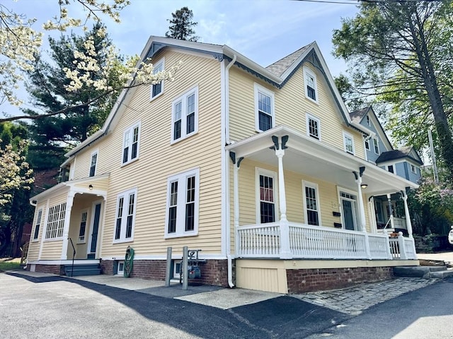 view of side of property featuring covered porch