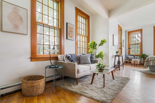 87 Bristol St Unit 3C, Cambridge, MA 02139 - living room featuring a baseboard radiator, wood finished floors, and beamed ceiling
