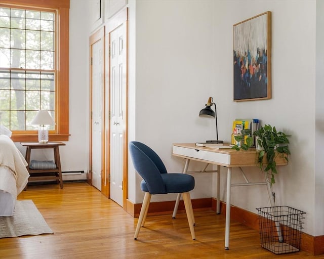 87 Bristol St Unit 3C, Cambridge, MA 02139 - office area featuring wood finished floors, plenty of natural light, a baseboard heating unit, and baseboards