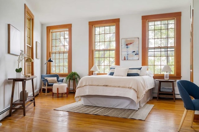 87 Bristol St Unit 3C, Cambridge, MA 02139 - bedroom with light wood-type flooring, a baseboard heating unit, and a baseboard radiator