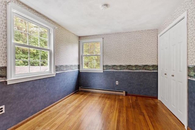 66 Park St, Pepperell, MA 01463 - unfurnished room featuring wallpapered walls, baseboard heating, wood finished floors, and a smoke detector