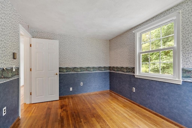 66 Park St, Pepperell, MA 01463 - spare room featuring wood finished floors and wallpapered walls
