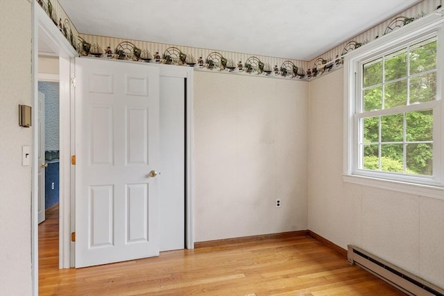 66 Park St, Pepperell, MA 01463 - empty room with a baseboard radiator and light wood-style floors