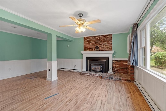 66 Park St, Pepperell, MA 01463 - unfurnished living room featuring baseboard heating, a baseboard radiator, ceiling fan, a brick fireplace, and a wainscoted wall