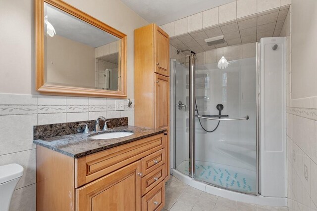 66 Park St, Pepperell, MA 01463 - bathroom featuring tile walls, vanity, a stall shower, tile patterned flooring, and wainscoting
