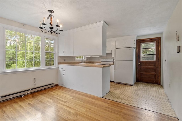 66 Park St, Pepperell, MA 01463 - kitchen with white appliances, a chandelier, light wood-style flooring, white cabinetry, and a peninsula