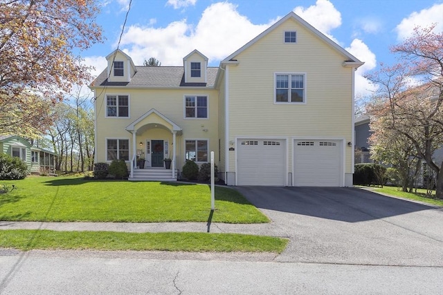 view of front of house featuring an attached garage, driveway, and a front lawn