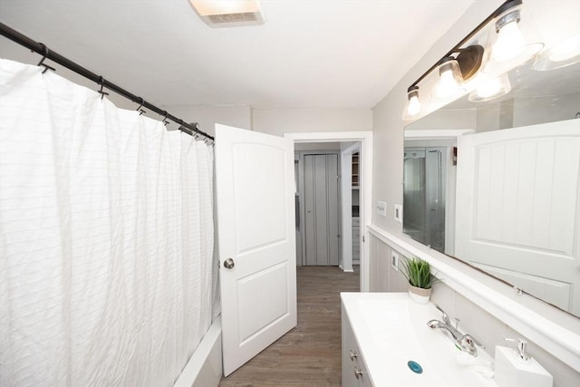 bathroom with shower / tub combo, wood finished floors, and vanity