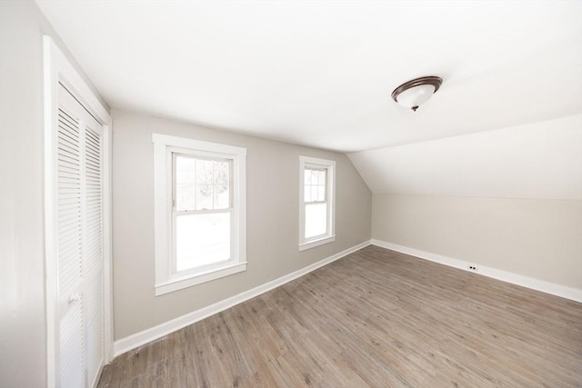 bonus room featuring lofted ceiling, wood finished floors, and baseboards