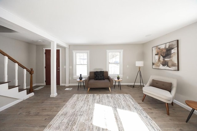 sitting room with stairs, wood finished floors, and baseboards