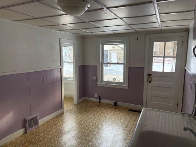 entryway featuring wainscoting, visible vents, plenty of natural light, and light floors