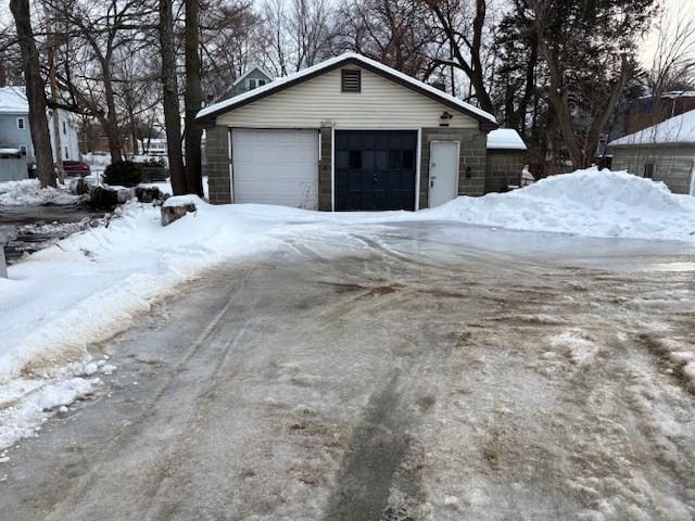 snow covered garage with a detached garage