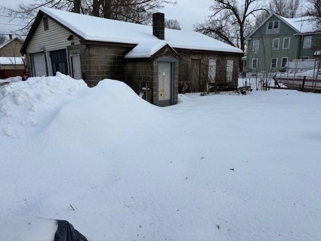 snowy yard with a detached garage