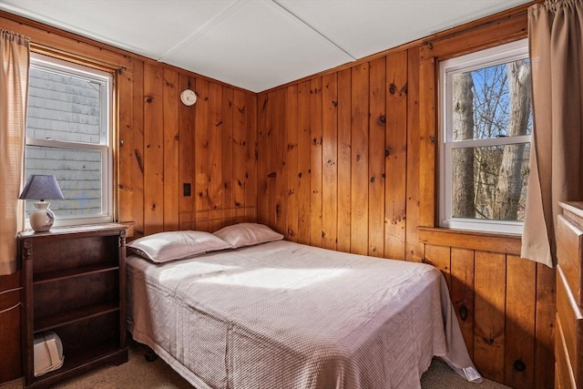 carpeted bedroom with wooden walls