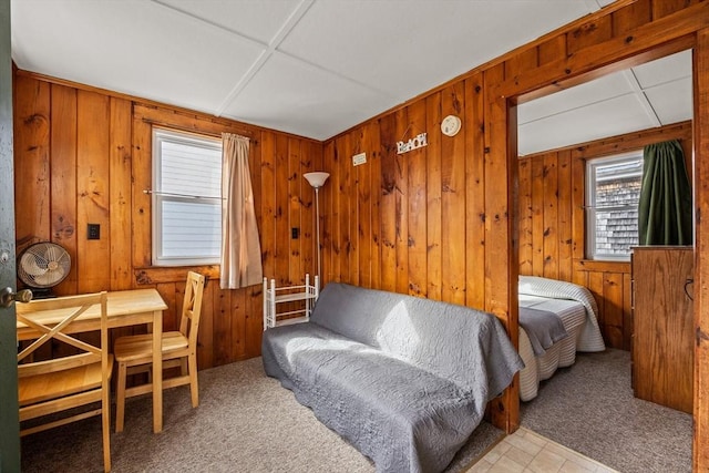 bedroom featuring wooden walls and carpet flooring