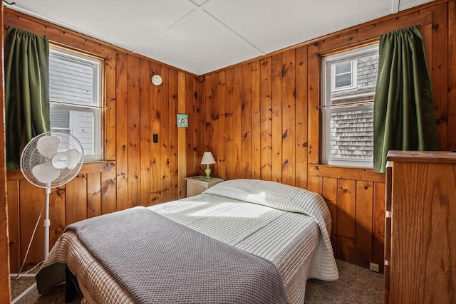 bedroom featuring carpet and wooden walls